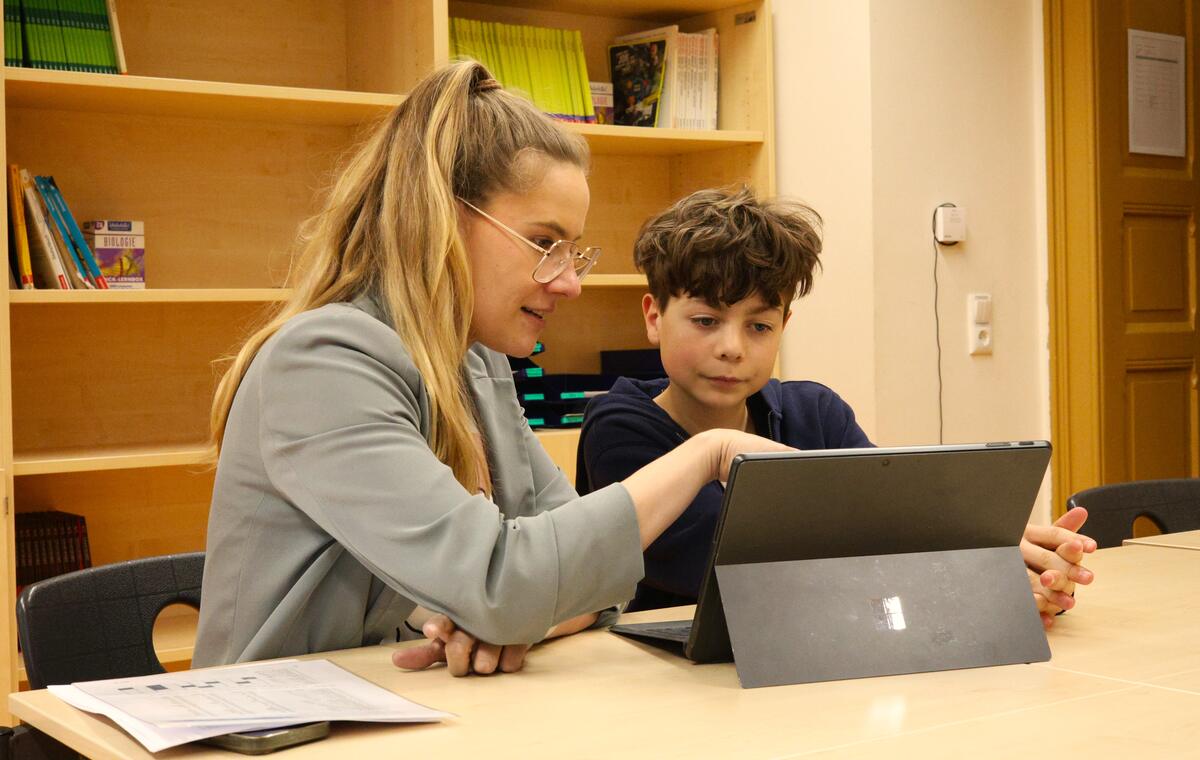 Eine Lehrerin und ein Schüler arbeiten gemeinsam am Tablet