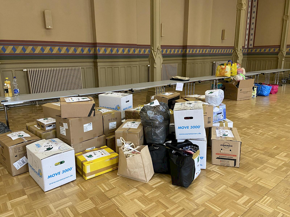 Gesammelte Hilfsgüter in Kartons in der Aula